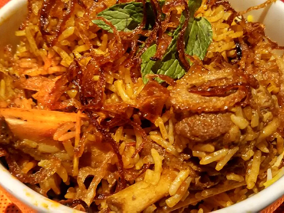 Slow-Cooked Lamb Shank Biryani — signature food visual for Carat Fine Indian and Mediterranean Cuisine